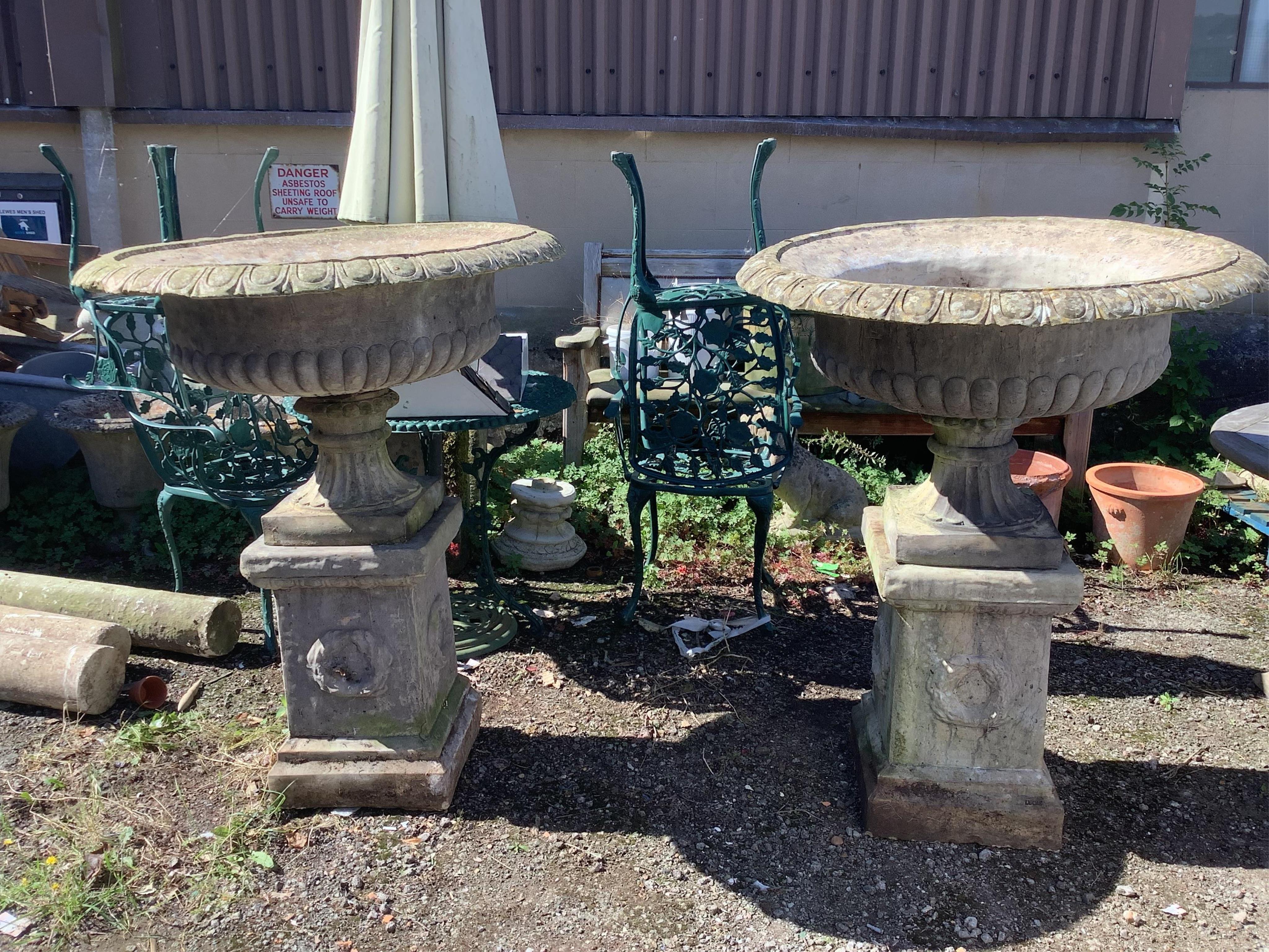 A pair of reconstituted stone campana garden urns on square pedestals, width 94cm, height 116cm. Condition - fair